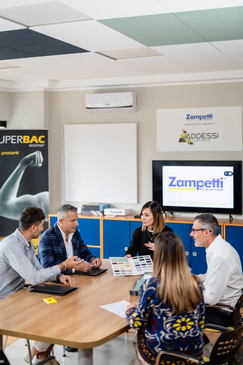 Assistenza tecnica e consulenza materiali edili – Zampetti Distribuzione Roma Assistenza tecnica e consulenza Zampetti Distribuzione nella sala riunioni con team e clienti